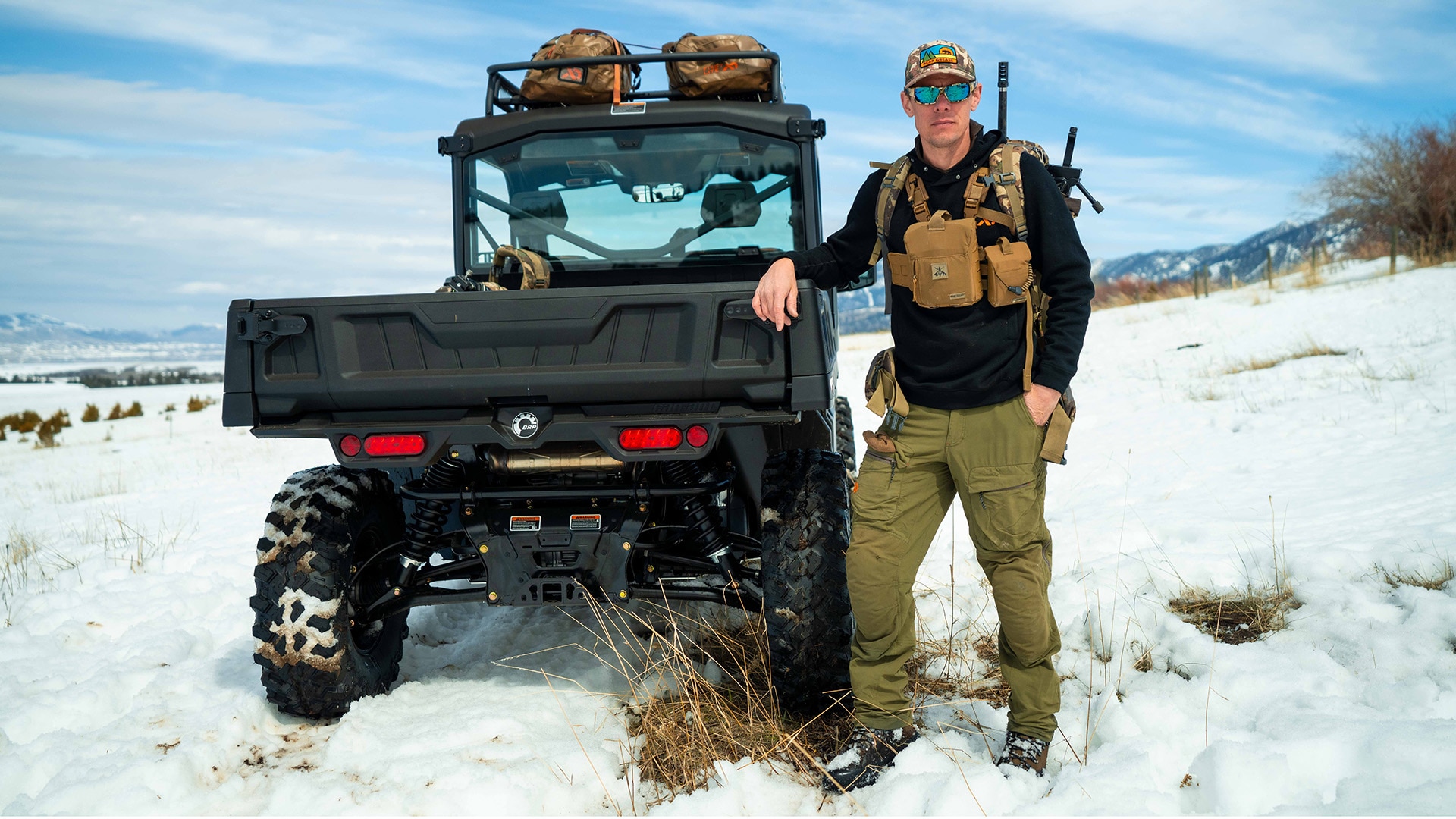 Chasseur à côté d'un côte-à-côte Defender de Can-Am